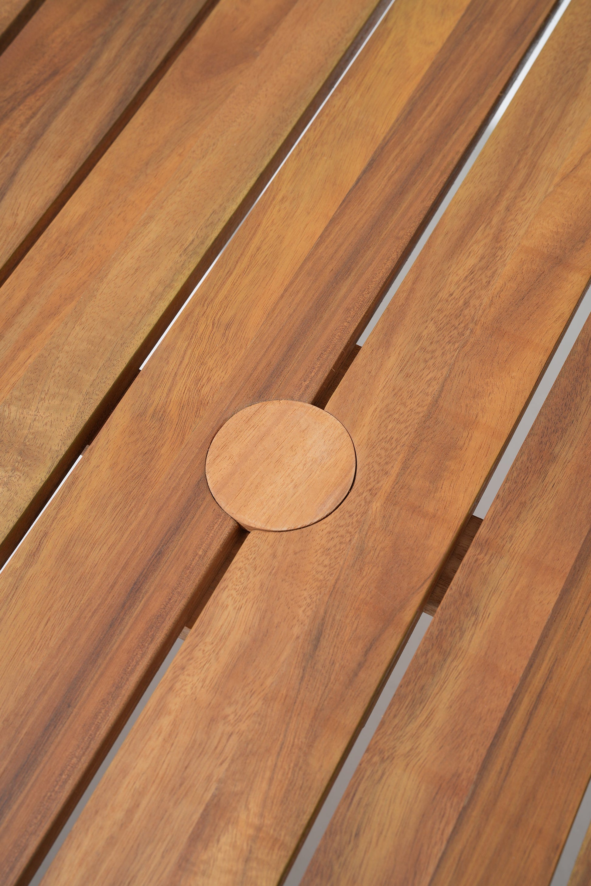 Close-up of wooden slats table with a circular cutout