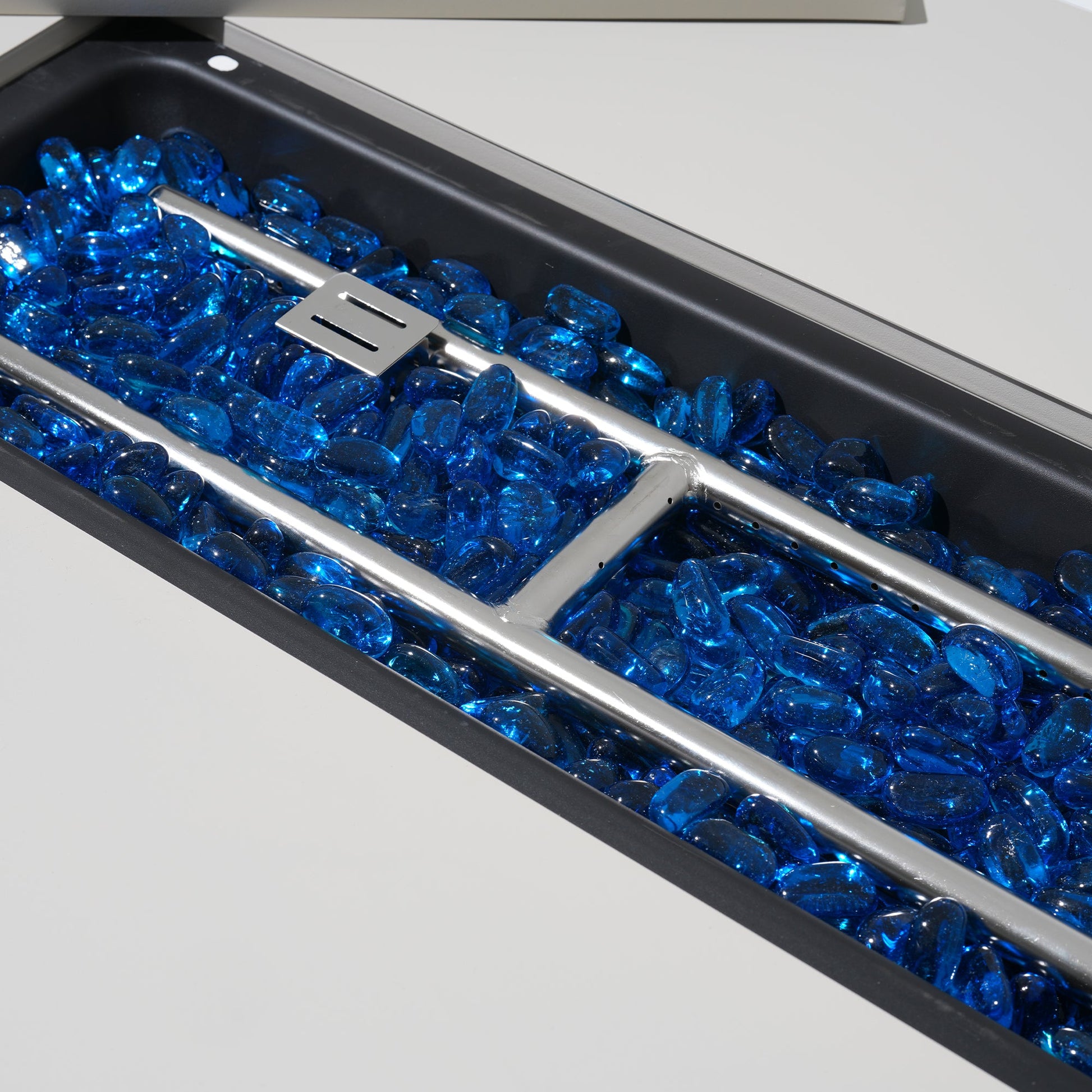 Close-up of a fire pit with blue glass stones