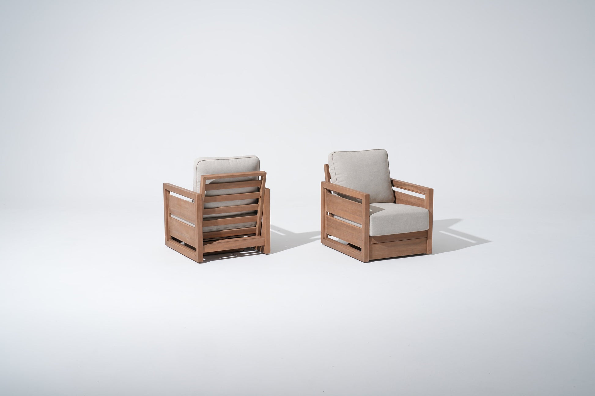 Two wooden swivel chairs with beige cushions 