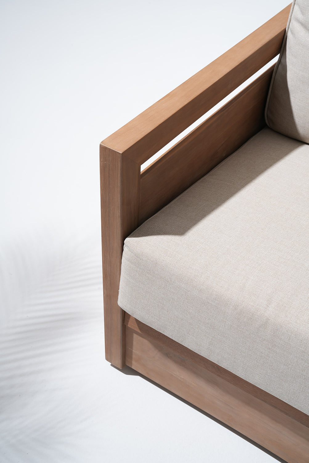 Wooden outdoor sofa with beige cushions, side detail