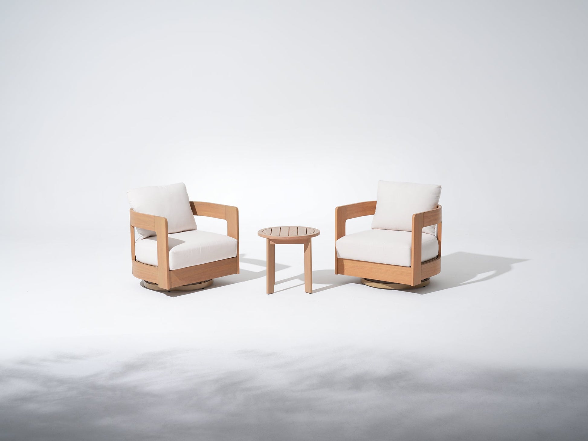 Two wooden swivel chairs with white cushions and a small round coffee table