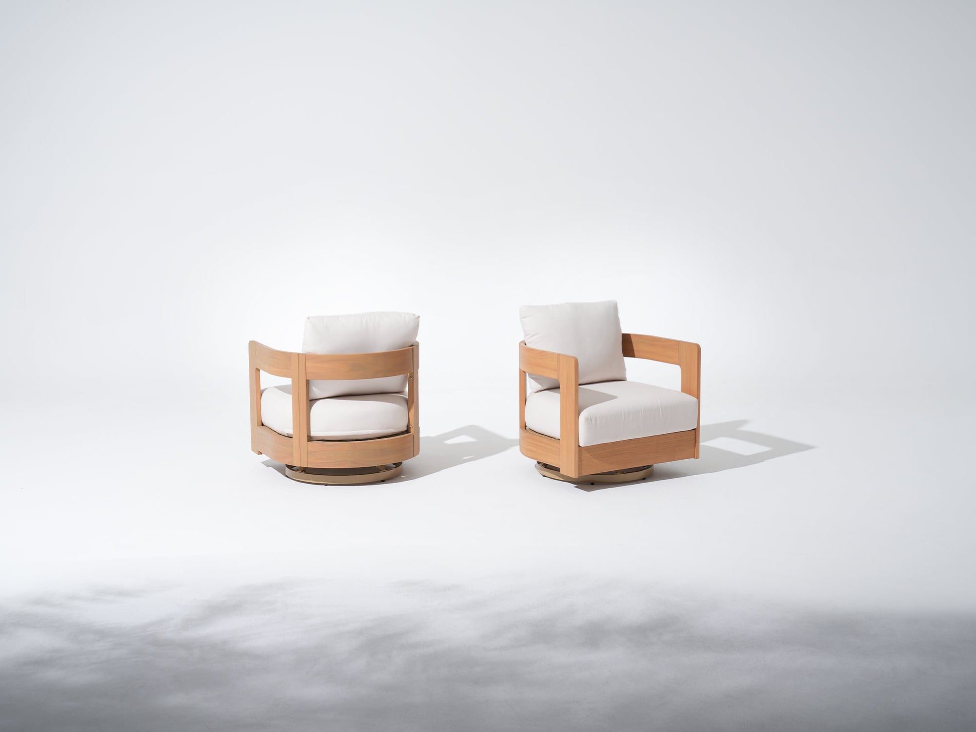 Two modern swivel chairs with wooden frames and white cushions