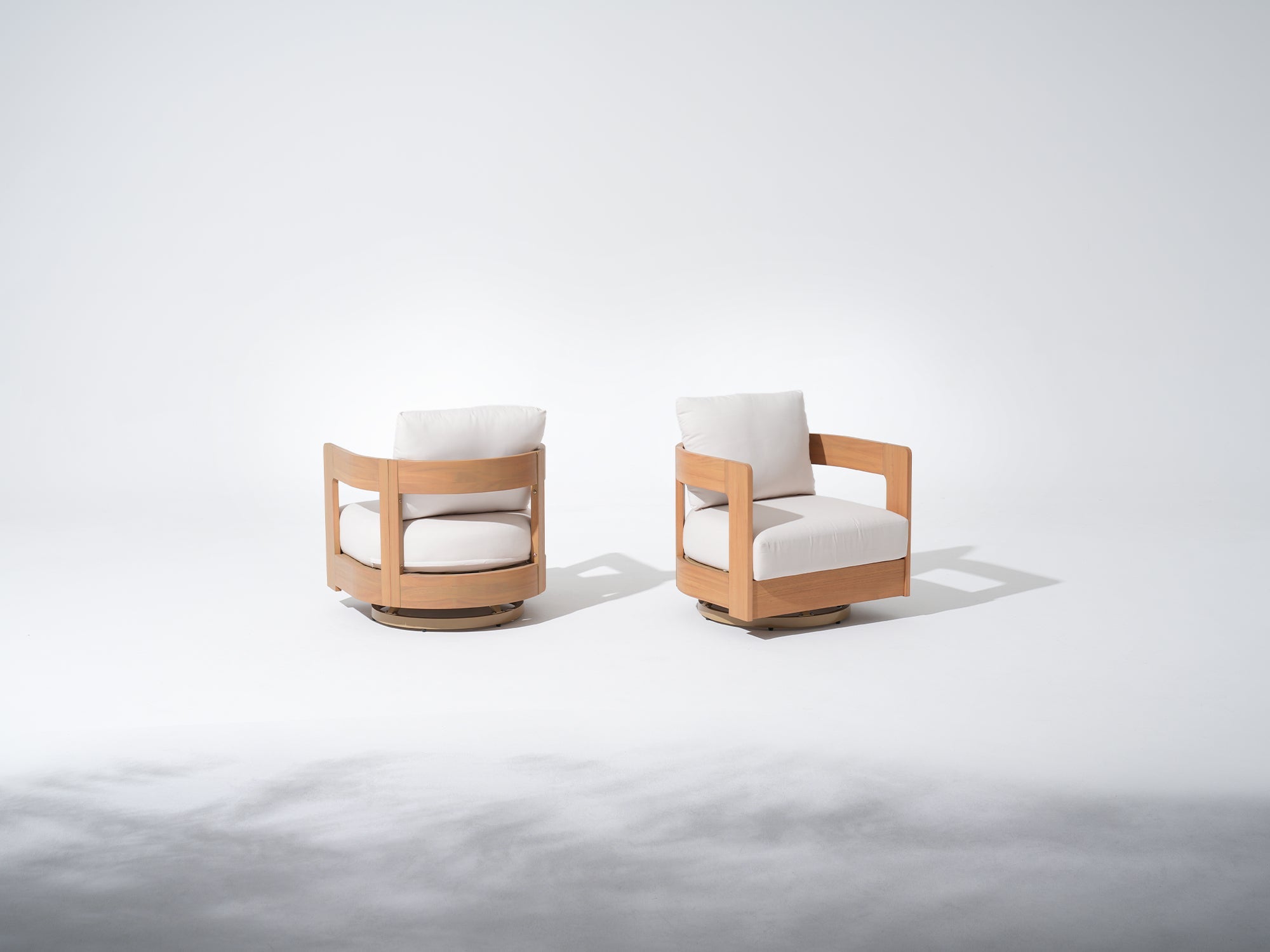 Two modern swivel chairs with wooden frames and white cushions