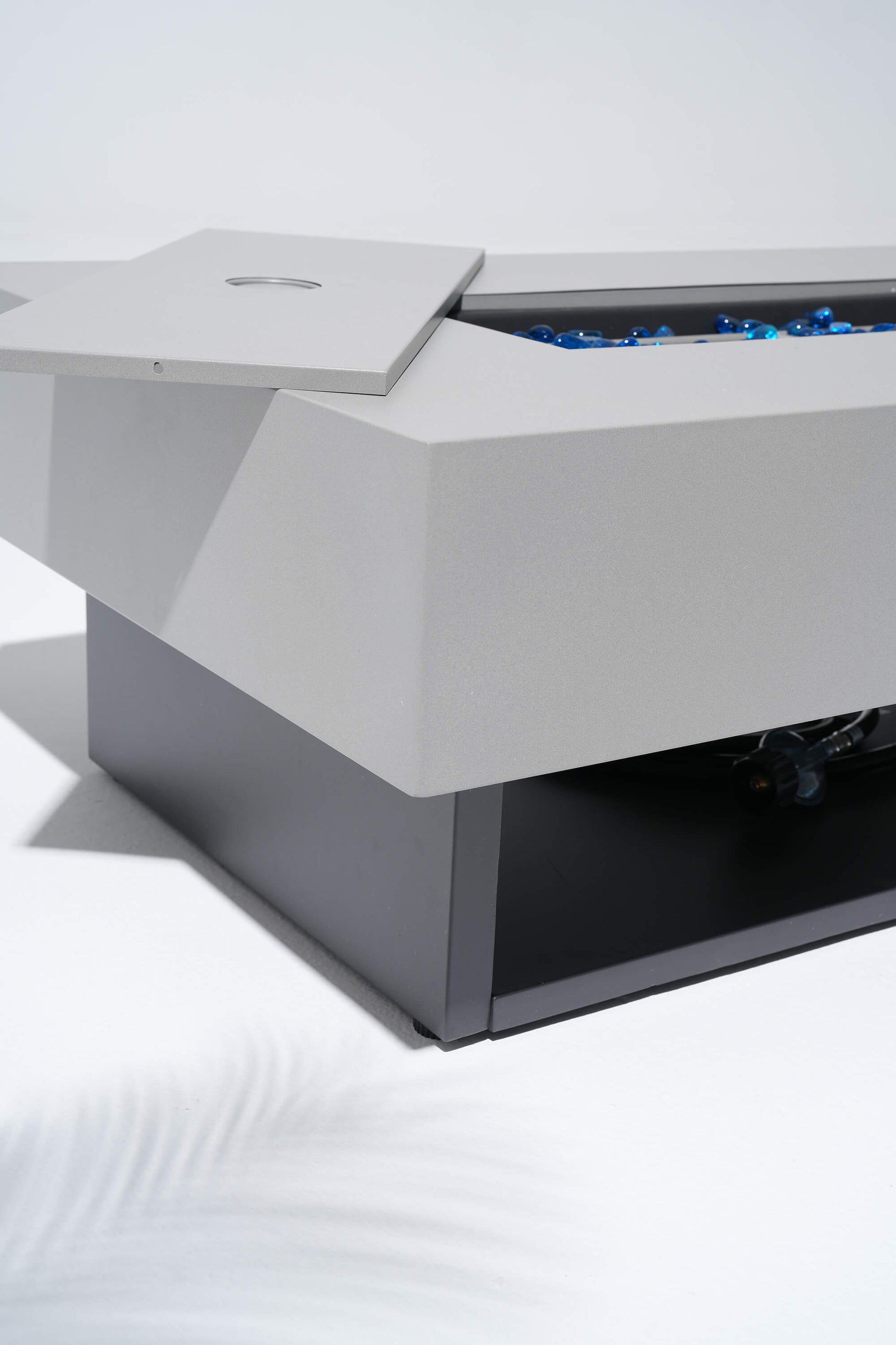 Modern outdoor fire pit table with blue flames on a white background #color_grey