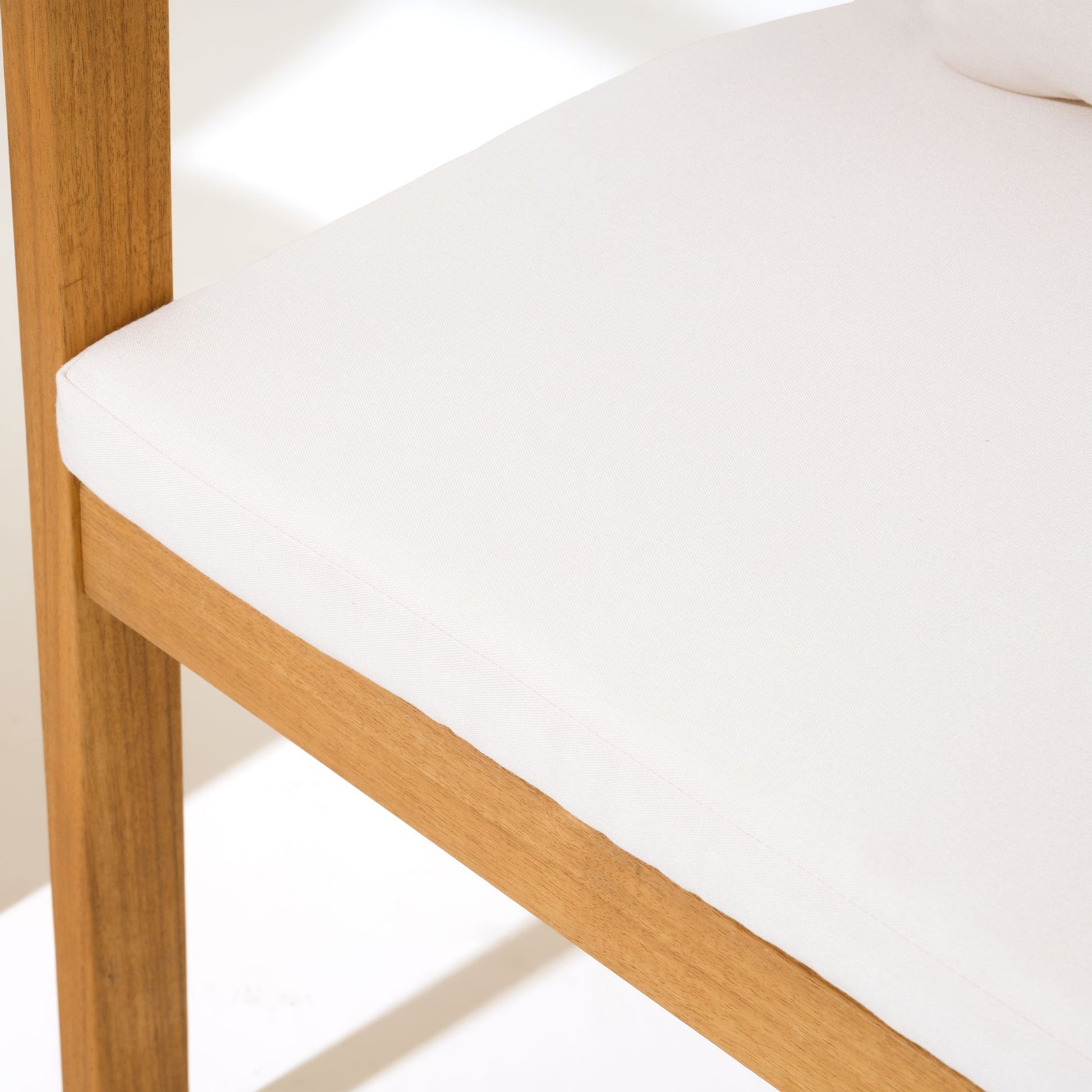 Close-up of a wooden chair with a white cushion- Sunsitt Modern Premium Patio Outdoor Furniture