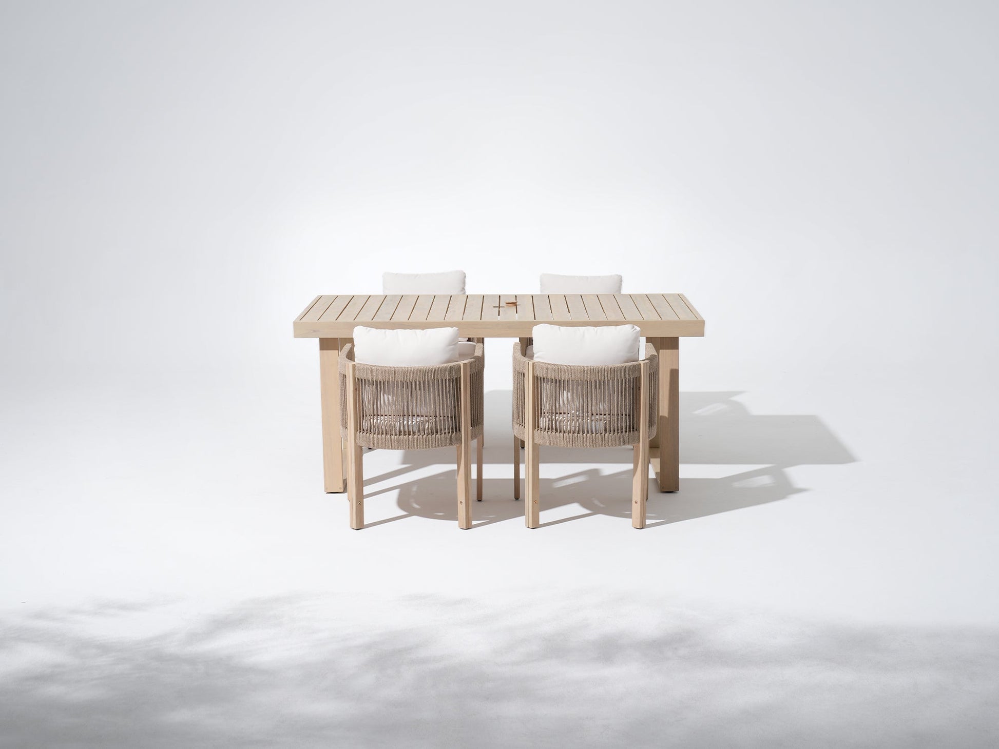 Wooden outdoor table with four matching chairs and umbrella hole