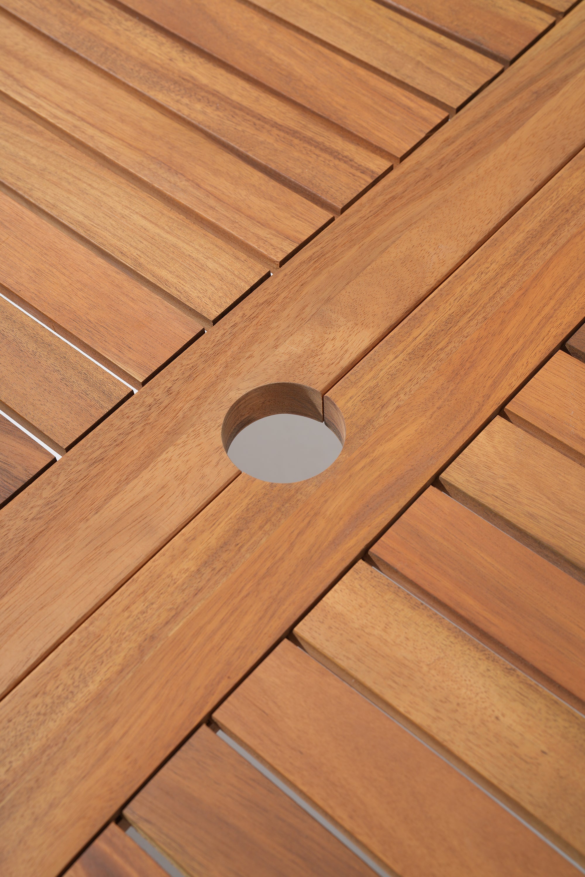 Close-up of wooden table with an umbrella hole