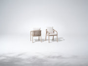 Two wood outdoor dining chairs with white cushions, rope design
