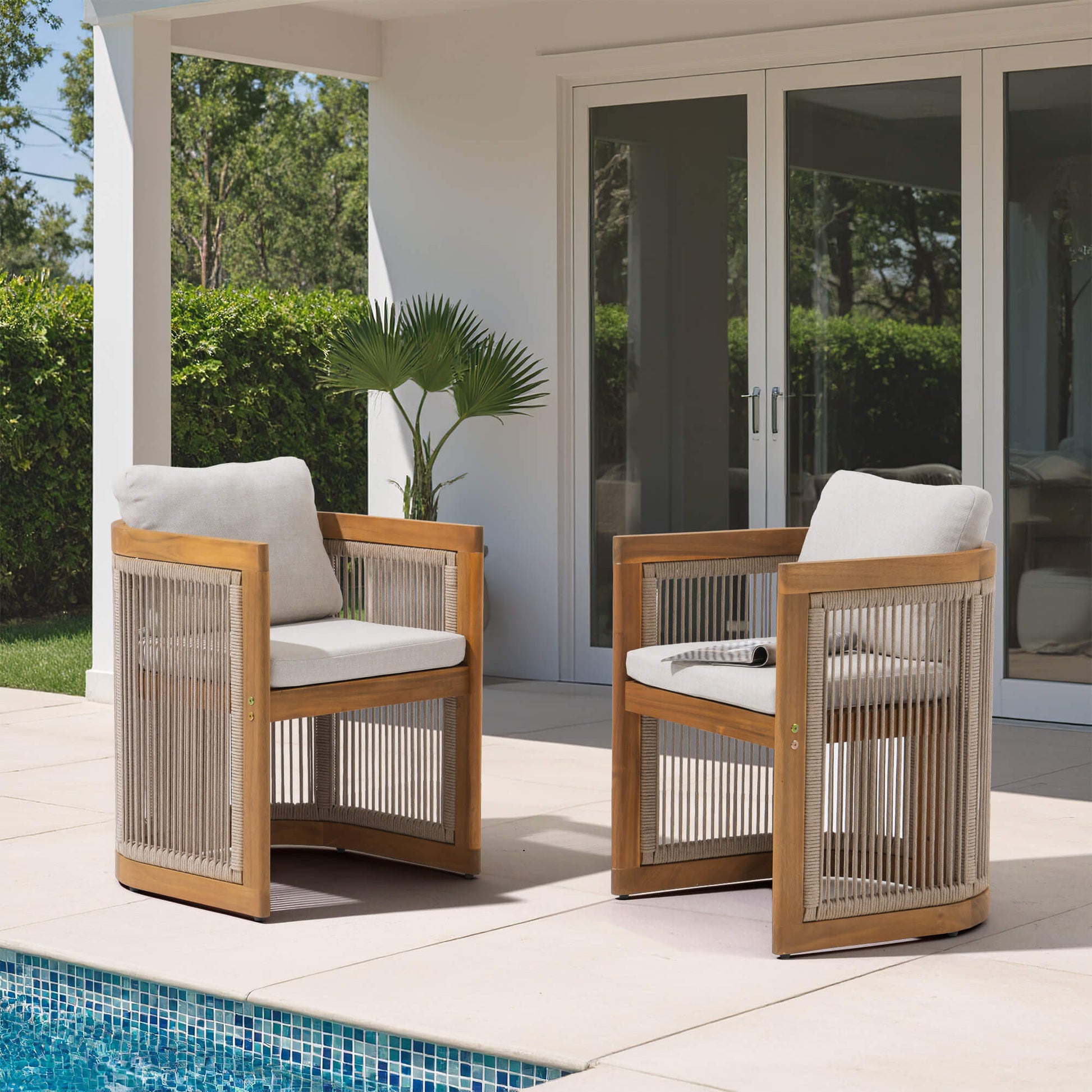 Two rope design wooden outdoor dining chairs with white cushions on a patio by a pool- Sunsitt Modern Premium Patio Outdoor Furniture 