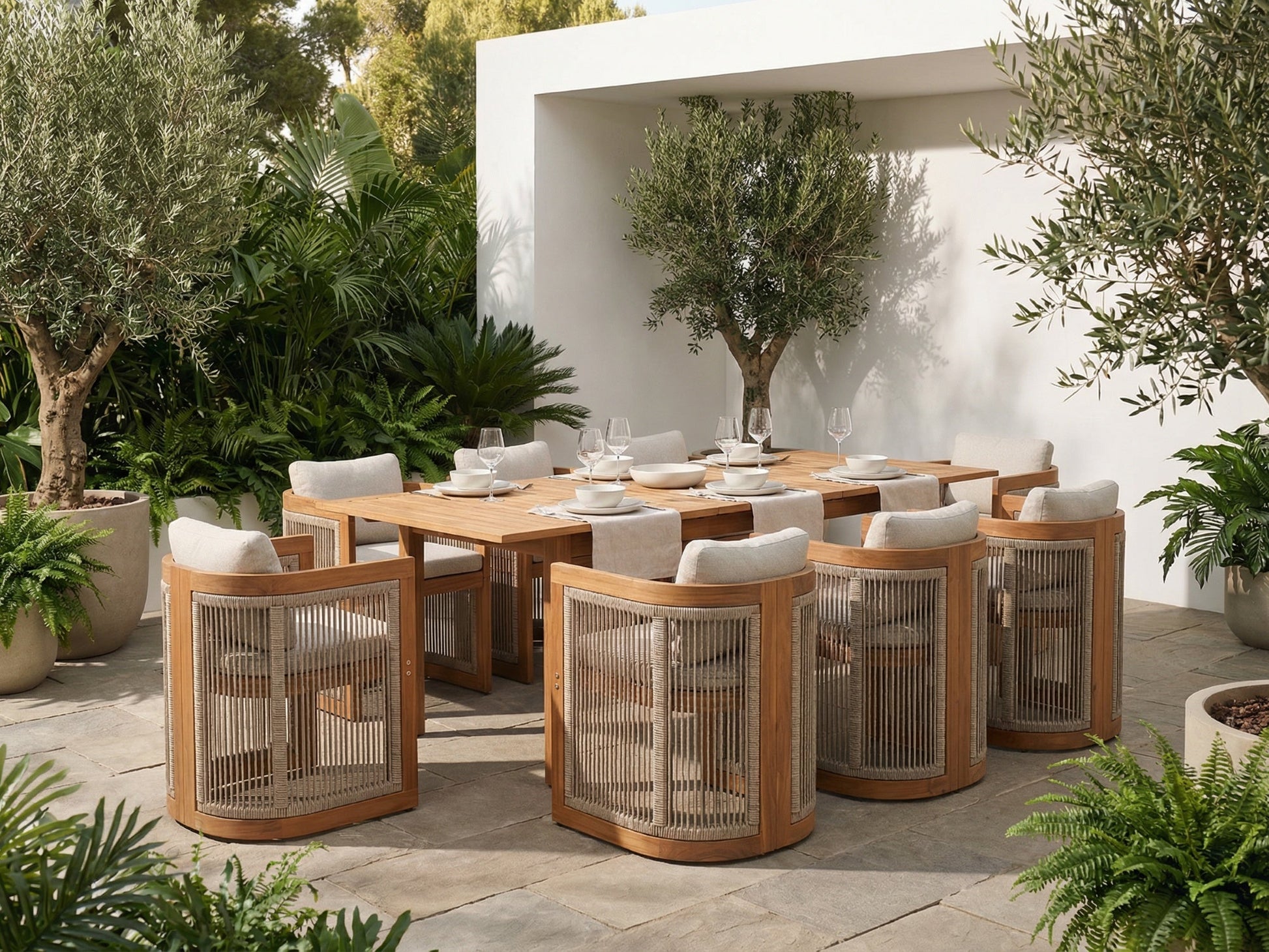 Outdoor dining set for 8 with wooden table and chairs surrounded by plants in a garden setting.
